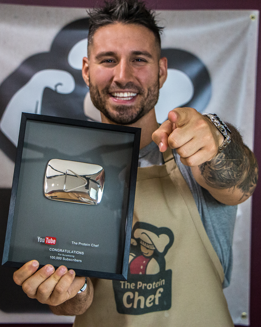 Derek Howes holding the 100k subscriber plaque